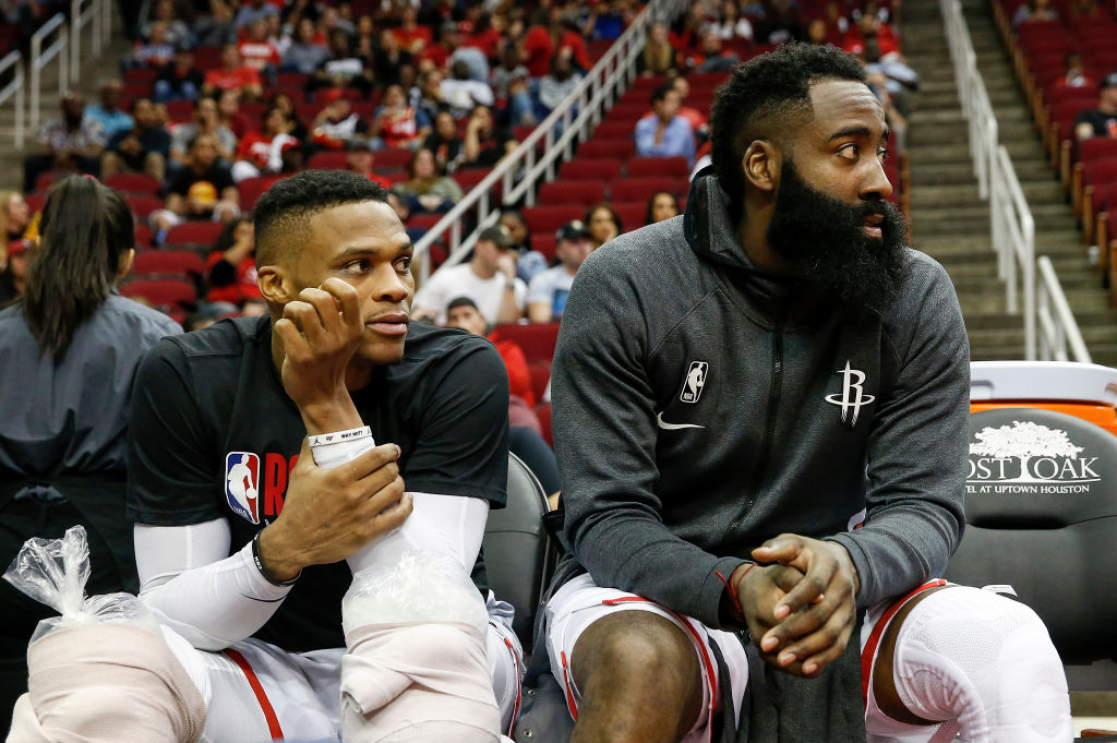 HOUSTON, TX - NOVEMBER 30: Russell Westbrook #0 of the Houston Rockets and James Harden #13 watch from the bench during the fourth quarter against the Atlanta Hawks at Toyota Center on November 30, 2019 in Houston, Texas. NOTE TO USER: User expressly acknowledges and agrees that, by downloading and or using this photograph, User is consenting to the terms and conditions of the Getty Images License Agreement. (Photo by Tim Warner/Getty Images)