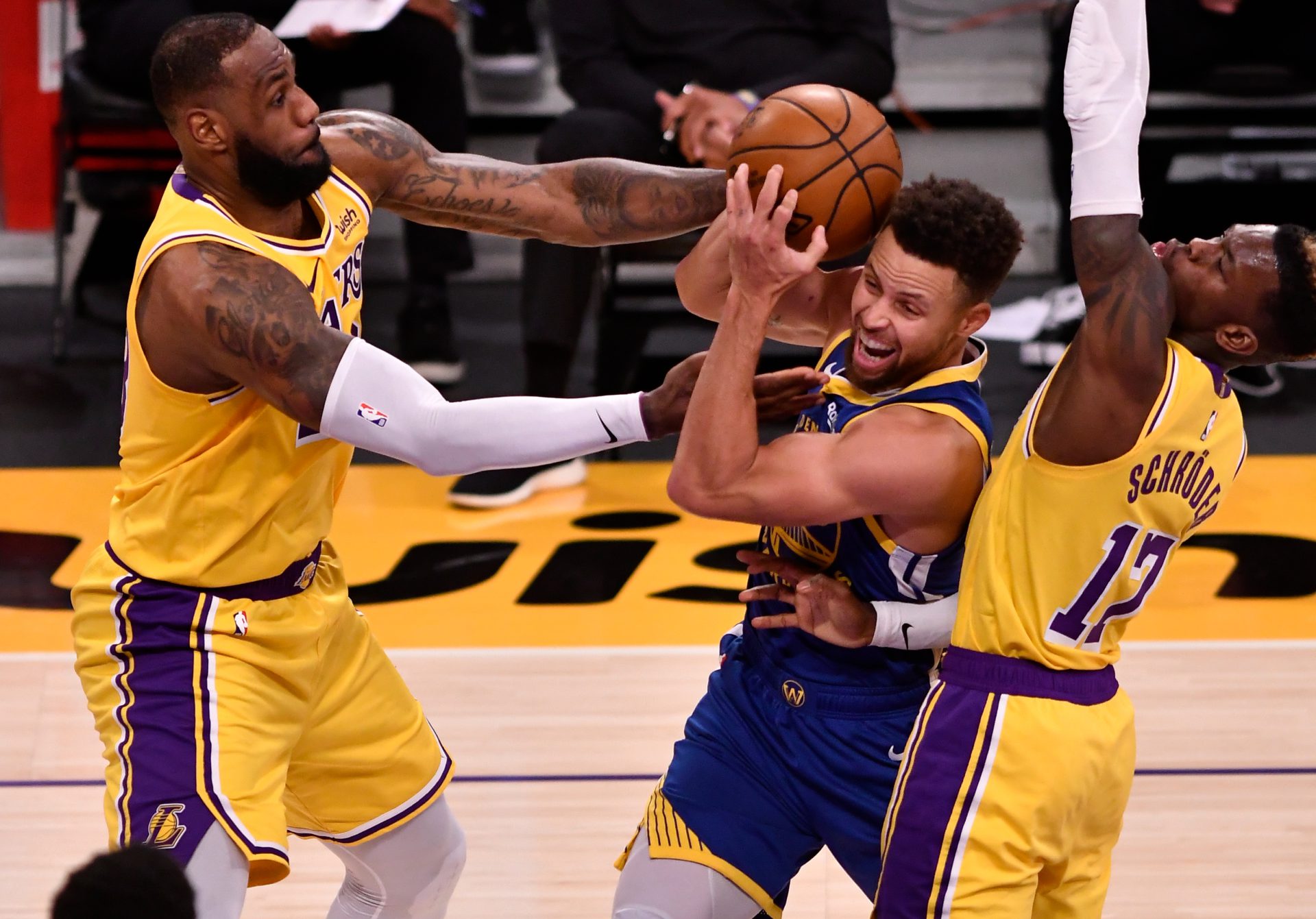 Jan 18, 2021; Los Angeles, California, USA; Golden State Warriors guard Stephen Curry (30) is sandwiched between Los Angeles Lakers forward LeBron James (23) and Los Angeles Lakers guard Dennis Schroder (17) during the third quarter at Staples Center. Mandatory Credit: Robert Hanashiro-USA TODAY Sports