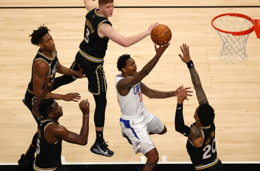 ATLANTA, GEORGIA - JANUARY 26: Lou Williams #23 of the LA Clippers drives against John Collins #20, Clint Capela #15, De'Andre Hunter #12 and Kevin Huerter #3 of the Atlanta Hawks during the first half at State Farm Arena on January 26, 2021 in Atlanta, Georgia. NOTE TO USER: User expressly acknowledges and agrees that, by downloading and or using this photograph, User is consenting to the terms and conditions of the Getty Images License Agreement. (Photo by Kevin C. Cox/Getty Images)