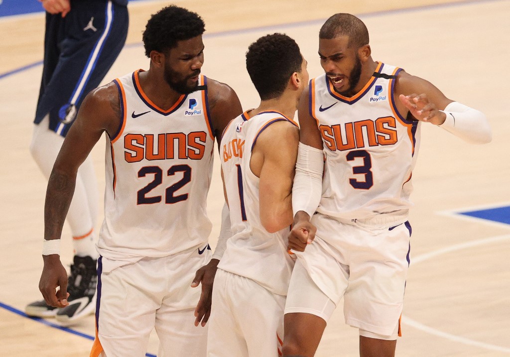 DALLAS, TEXAS - FEBRUARY 01: Devin Booker #1 celebrates the game winning shot with Deandre Ayton #22 and Chris Paul #3 of the Phoenix Suns against the Dallas Mavericks in the fourth quarter at American Airlines Center on February 01, 2021 in Dallas, Texas. NOTE TO USER: User expressly acknowledges and agrees that, by downloading and/or using this Photograph, User is consenting to the terms and conditions of the Getty Images License Agreement.   Ronald Martinez/Getty Images/AFP (Photo by RONALD MARTINEZ / GETTY IMAGES NORTH AMERICA / AFP)