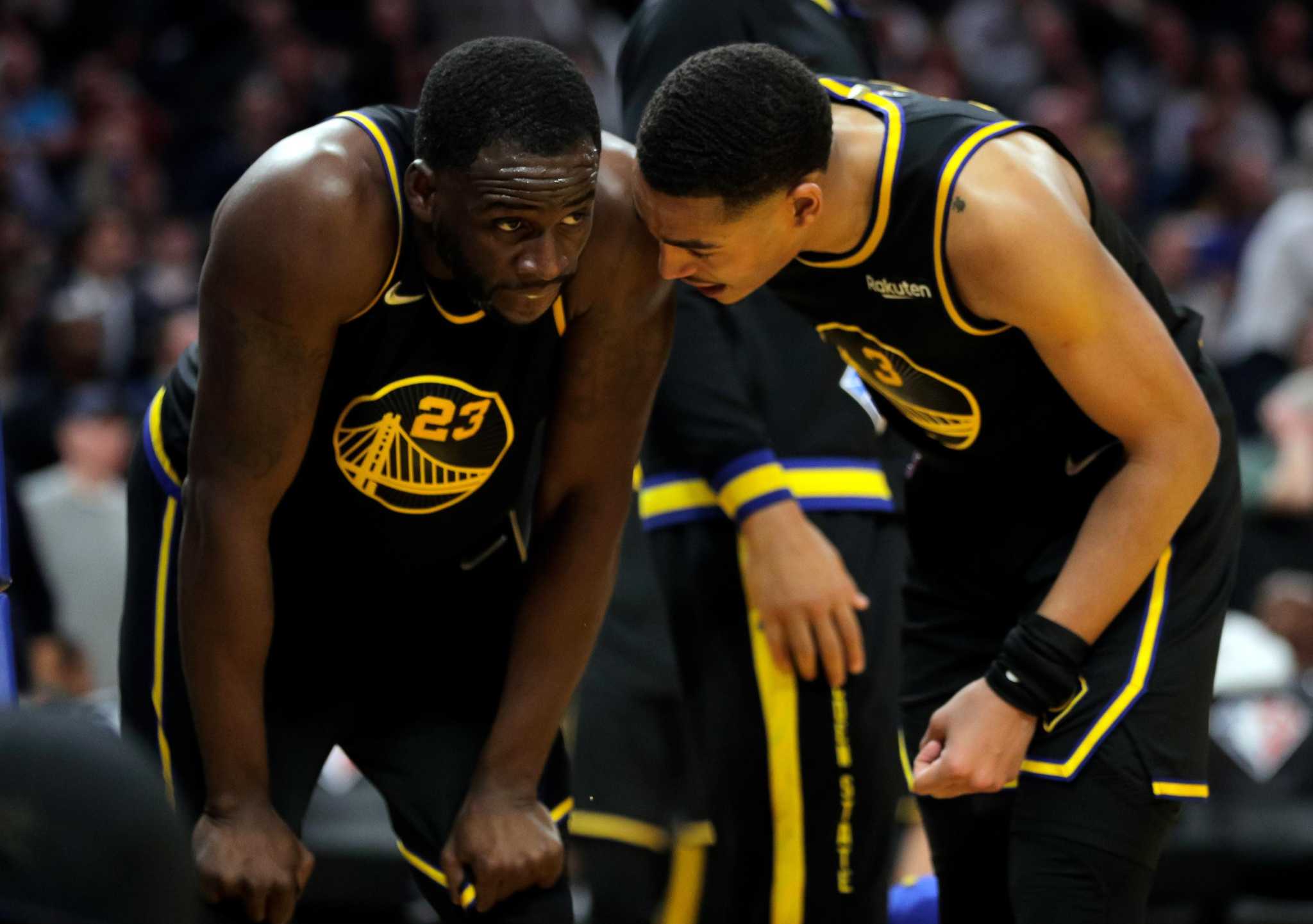 Jordan Poole (3) checks on Draymond Green (23) after he was fouled and fell to court in the second half as the Golden State Warriors played the Phoenix Suns at Chase Center in San Francisco, Calif., on Wednesday, March 30, 2022.
